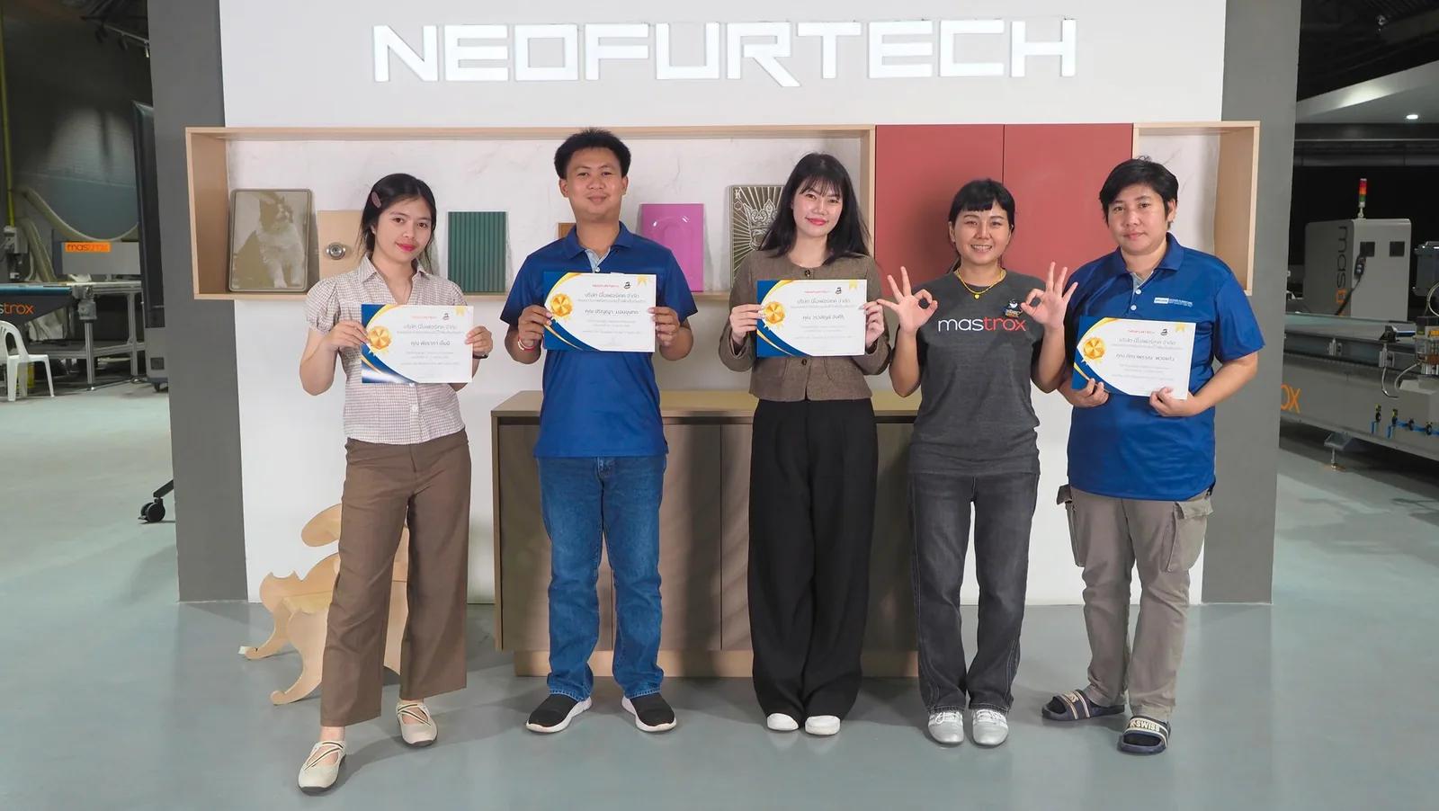 ผู้เรียนถือใบประกาศนียบัตรคอร์ส PanelOrca หน้าป้าย Neofurtech